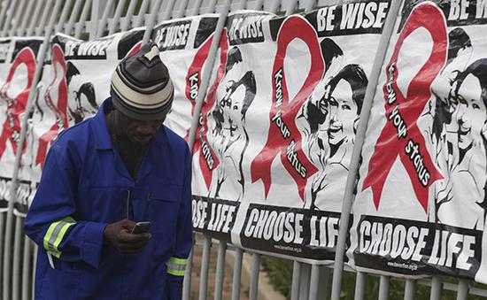 南非約翰內斯堡，男子經過防艾宣傳海報。東方IC 資料&nbsp;